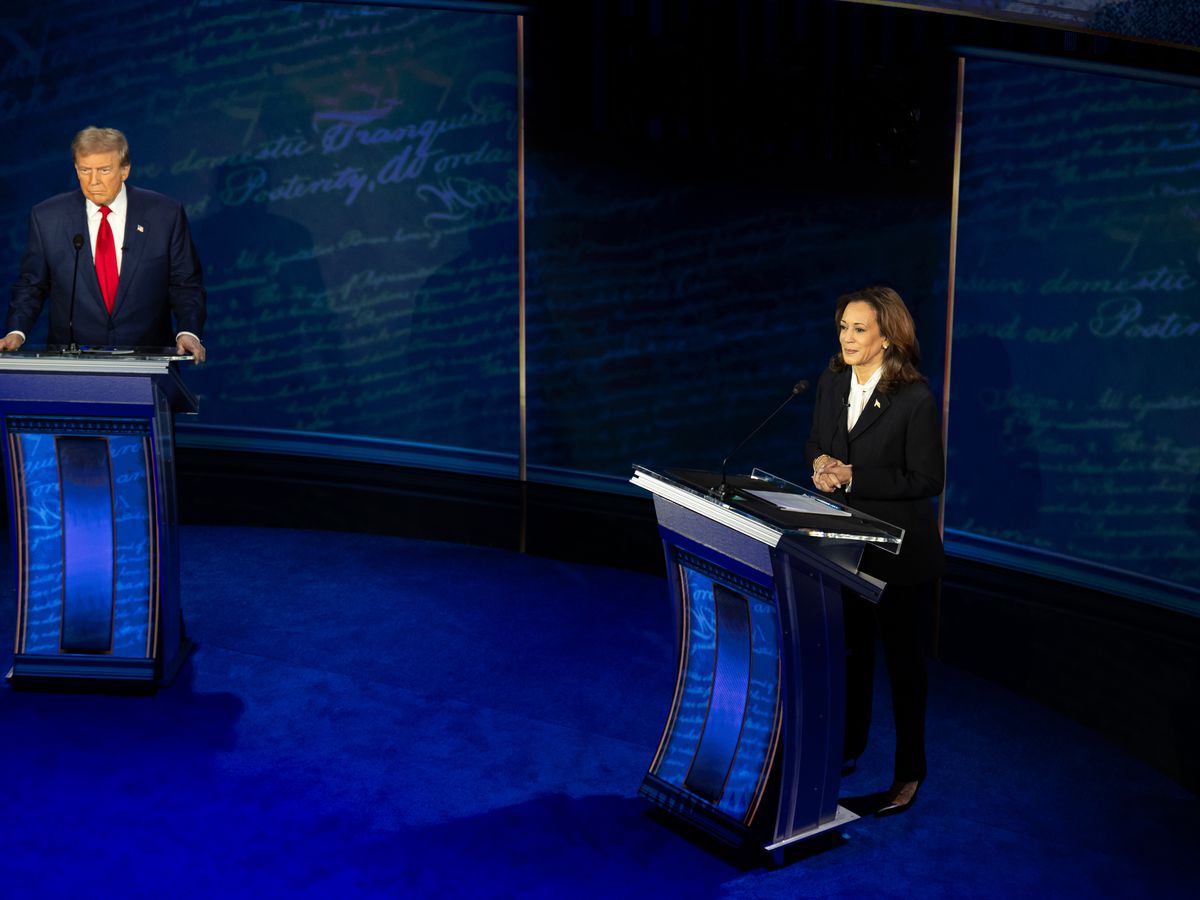 Two people standing behind podiums on a stage.