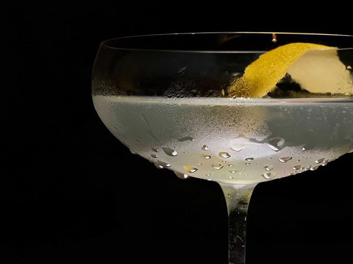 A martini in a coupe glass with a lemon peel.