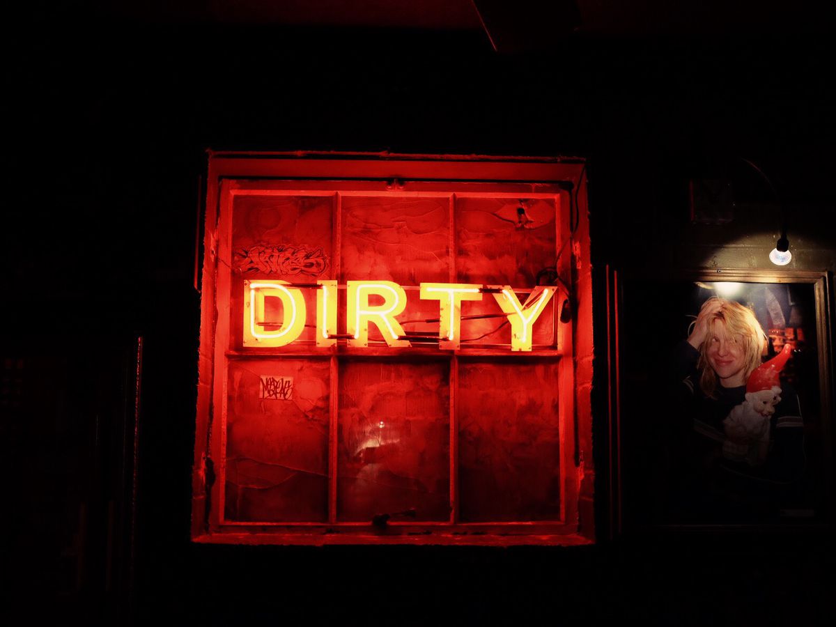 A lit-up neon sign that reads DIRTY.