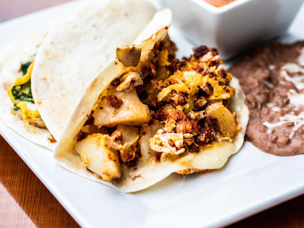 A taco with ground meat and cheese and potatoes. 