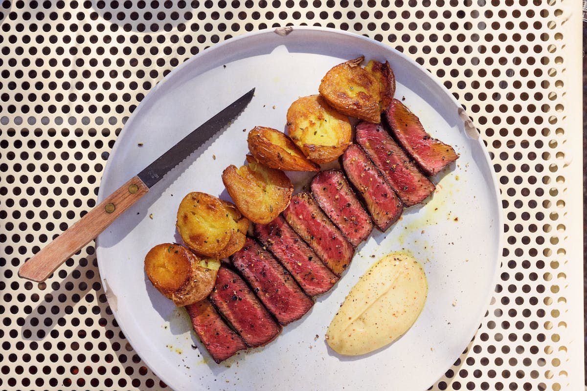 A plate of potatoes and steak.