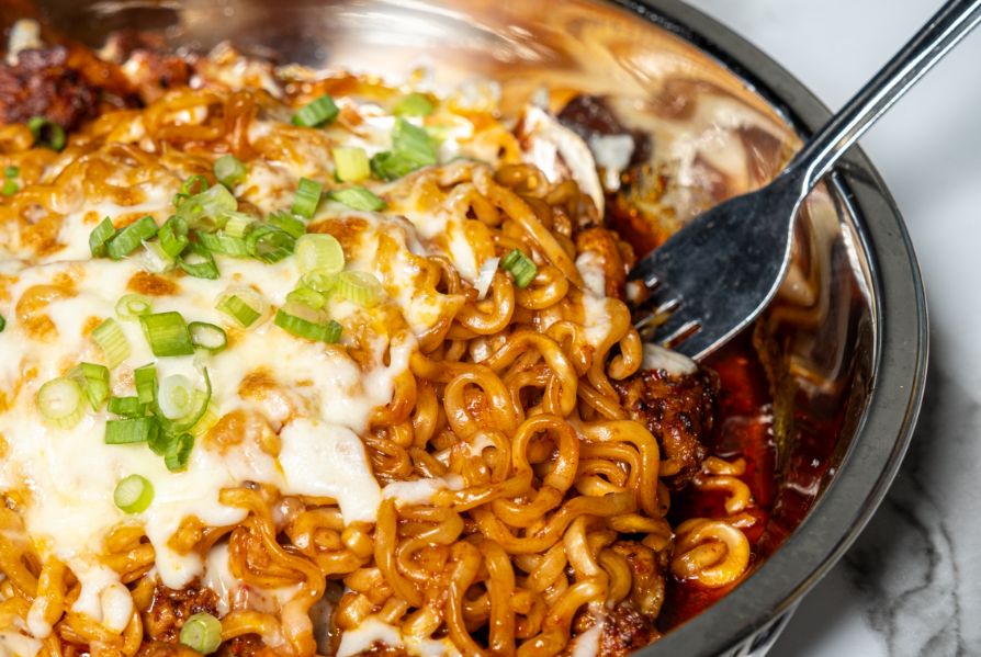 A bowl of saucy cheese noodles.
