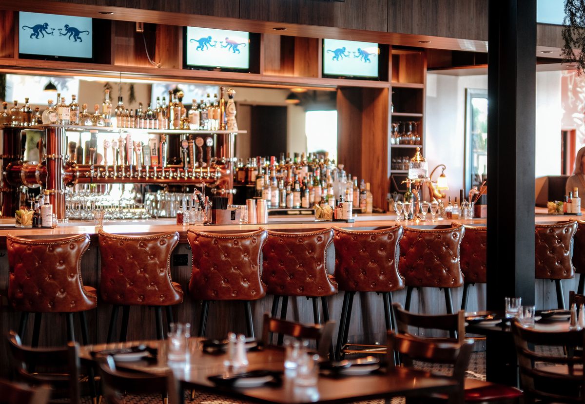 The interior of Odds Bistro & Bar with brown leather bar stools.