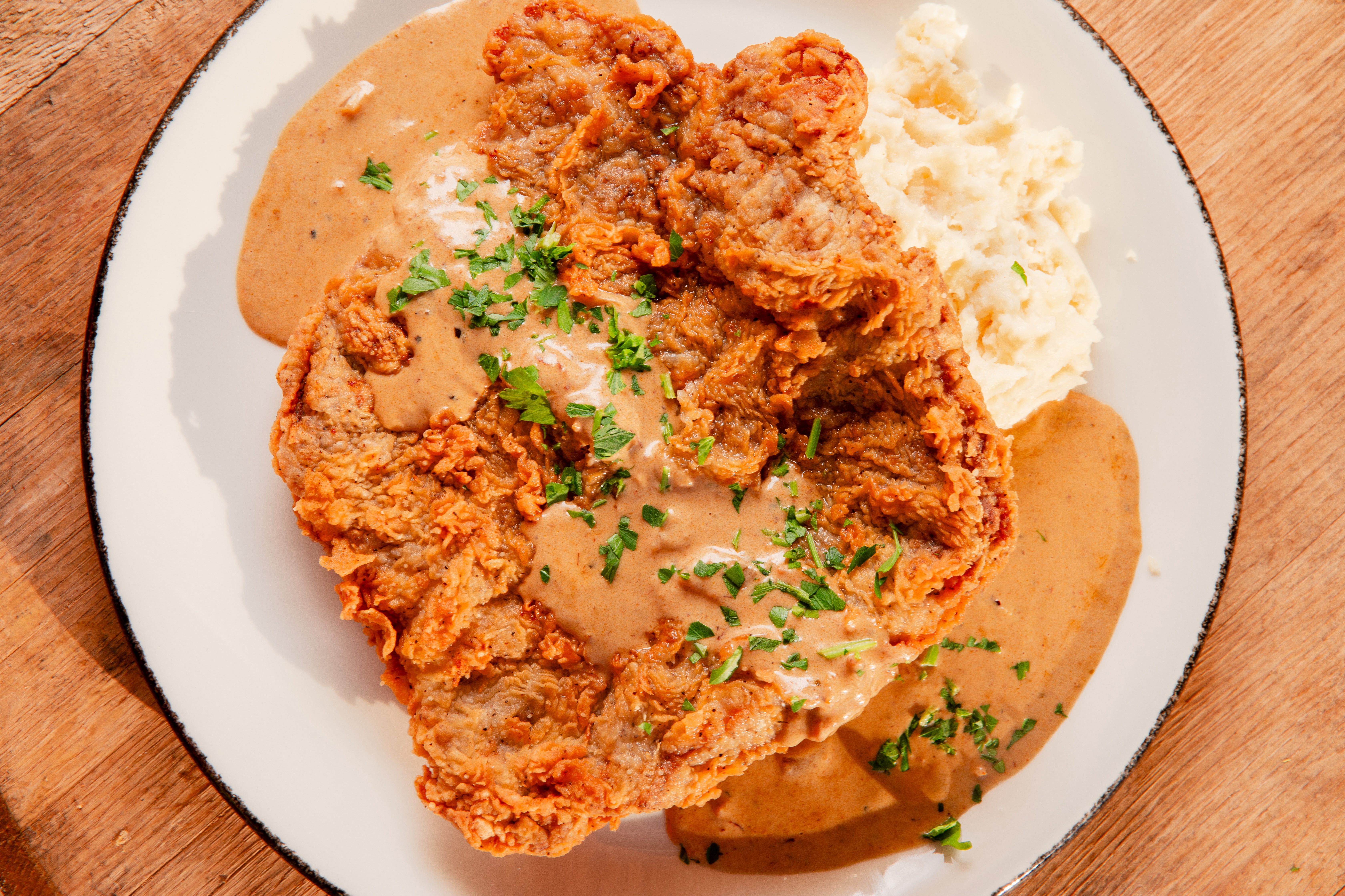A fried steak on a plate with sauce.