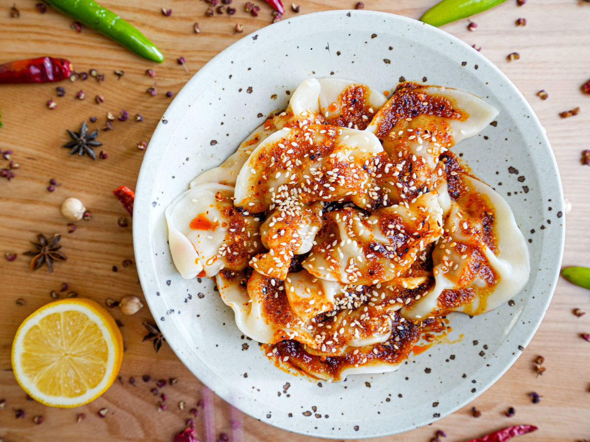 A plate of dumplings doused in a red oil.