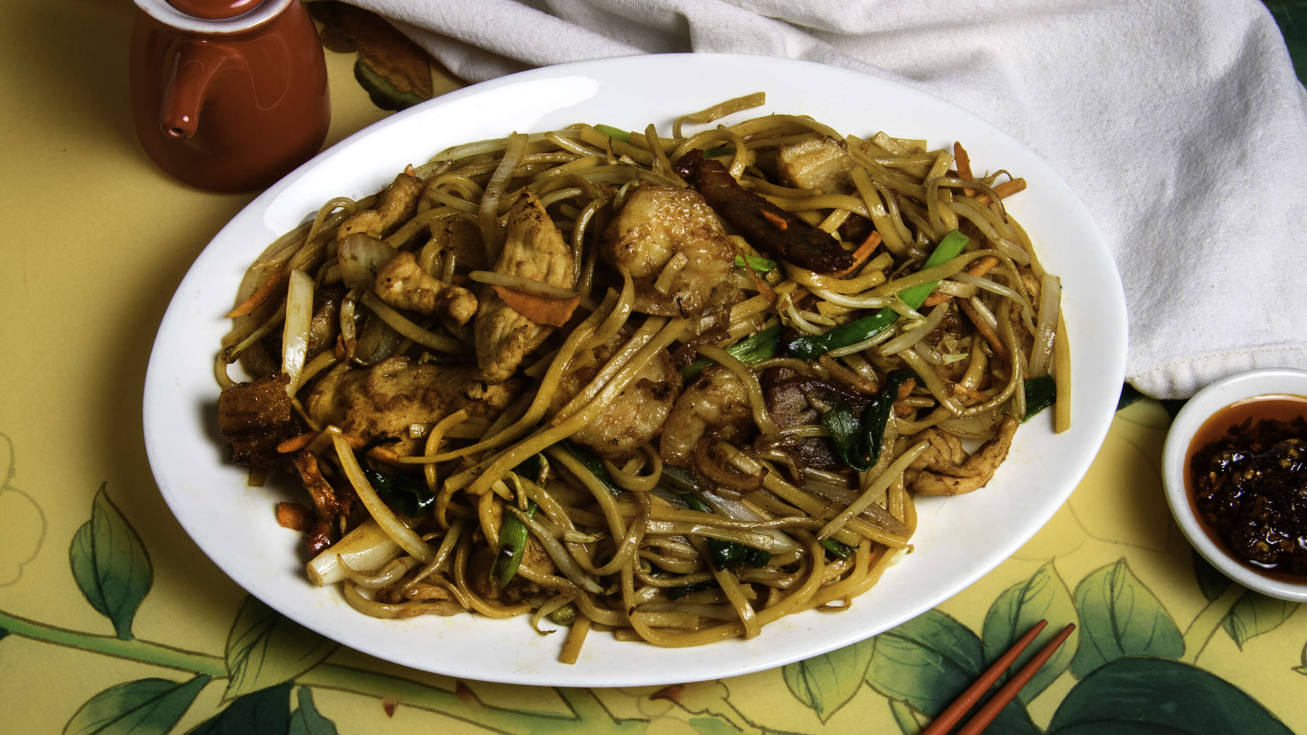 An oval plate of noodles and meats.