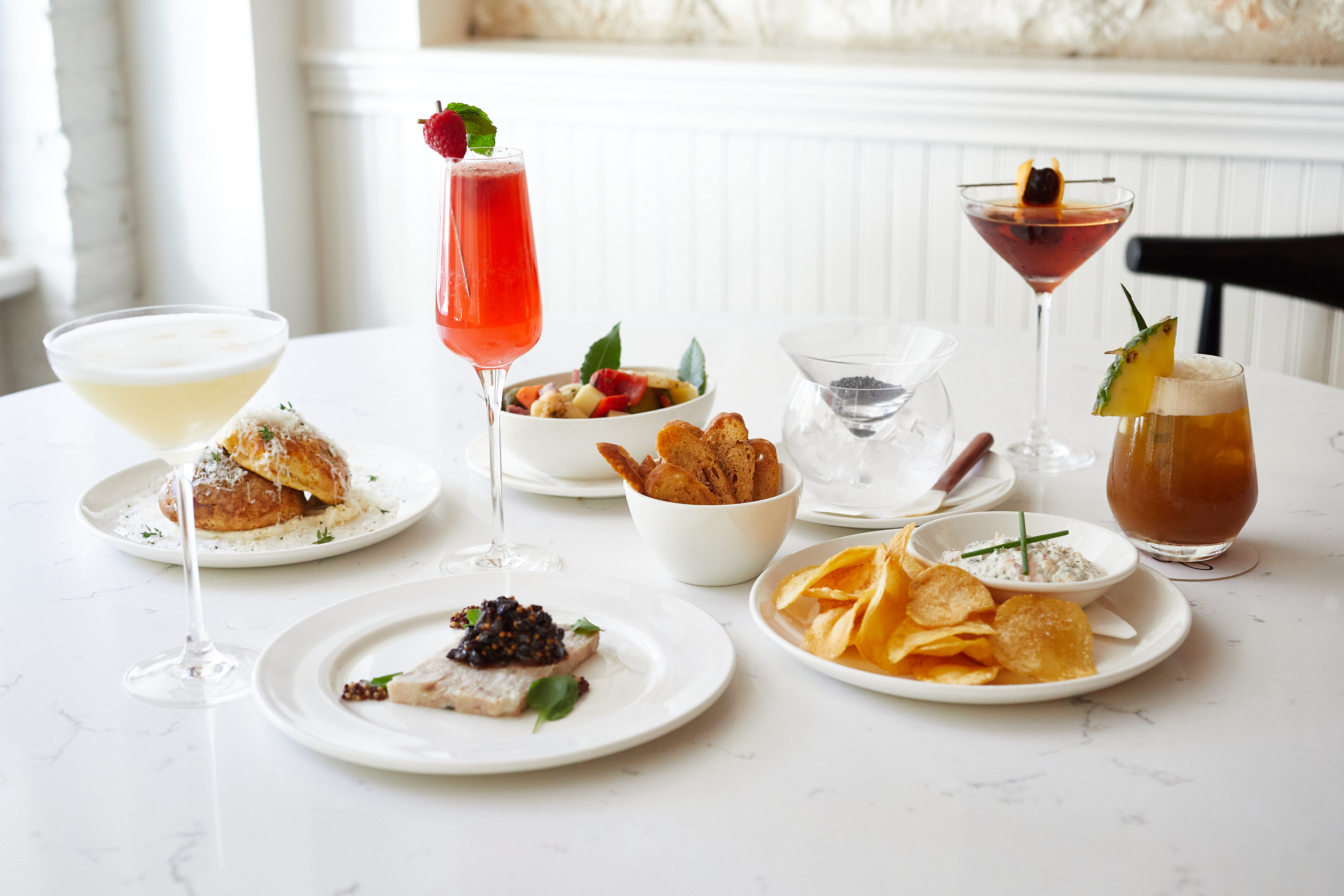 A table of food on plates and drinks in glasses.