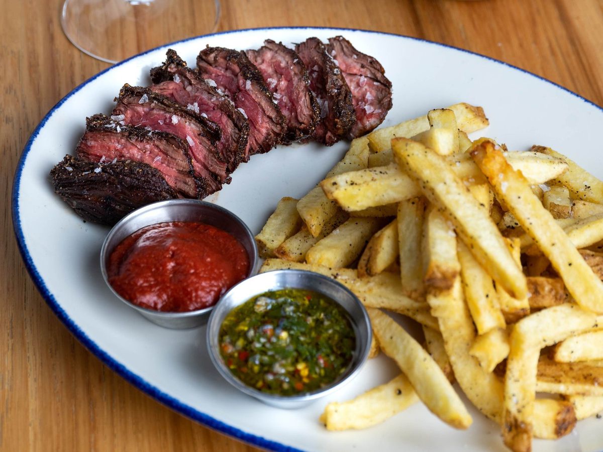 A plate of sliced steak and fries.