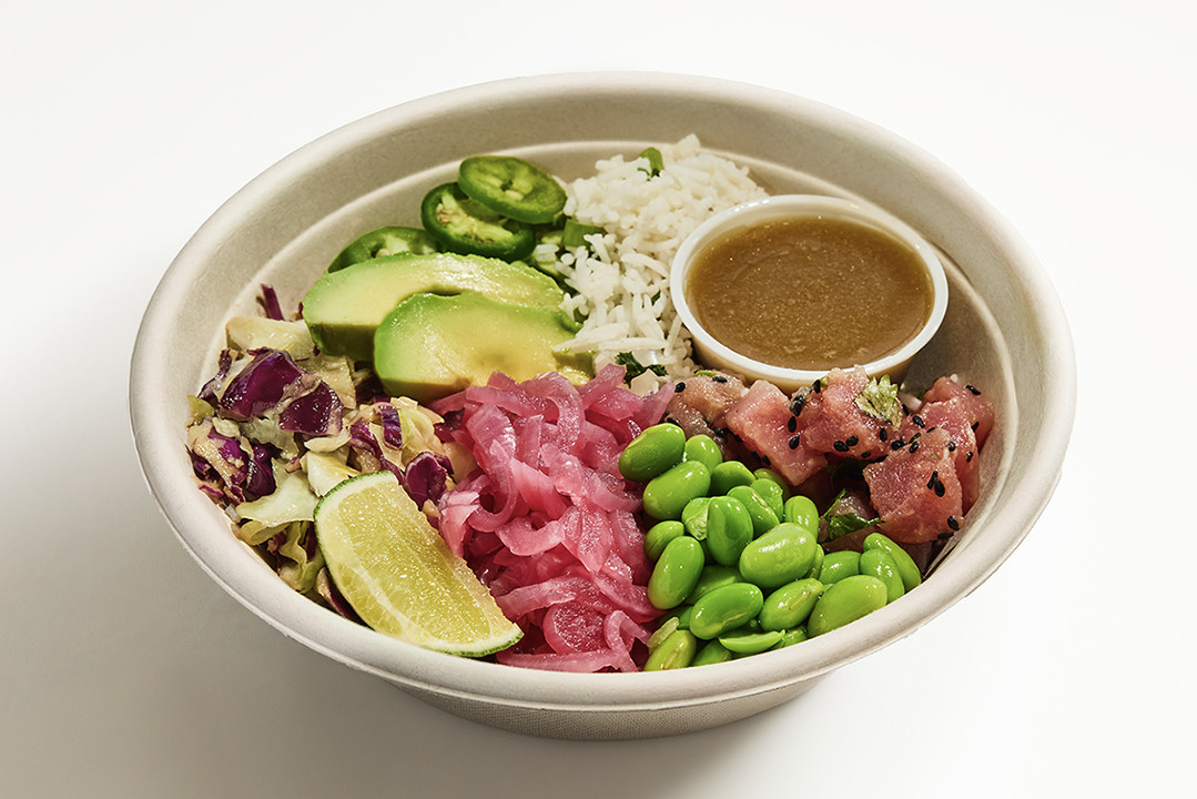 A tuna poke bowl has edamame, limes, jalapeños, pickled red onions, and rice.