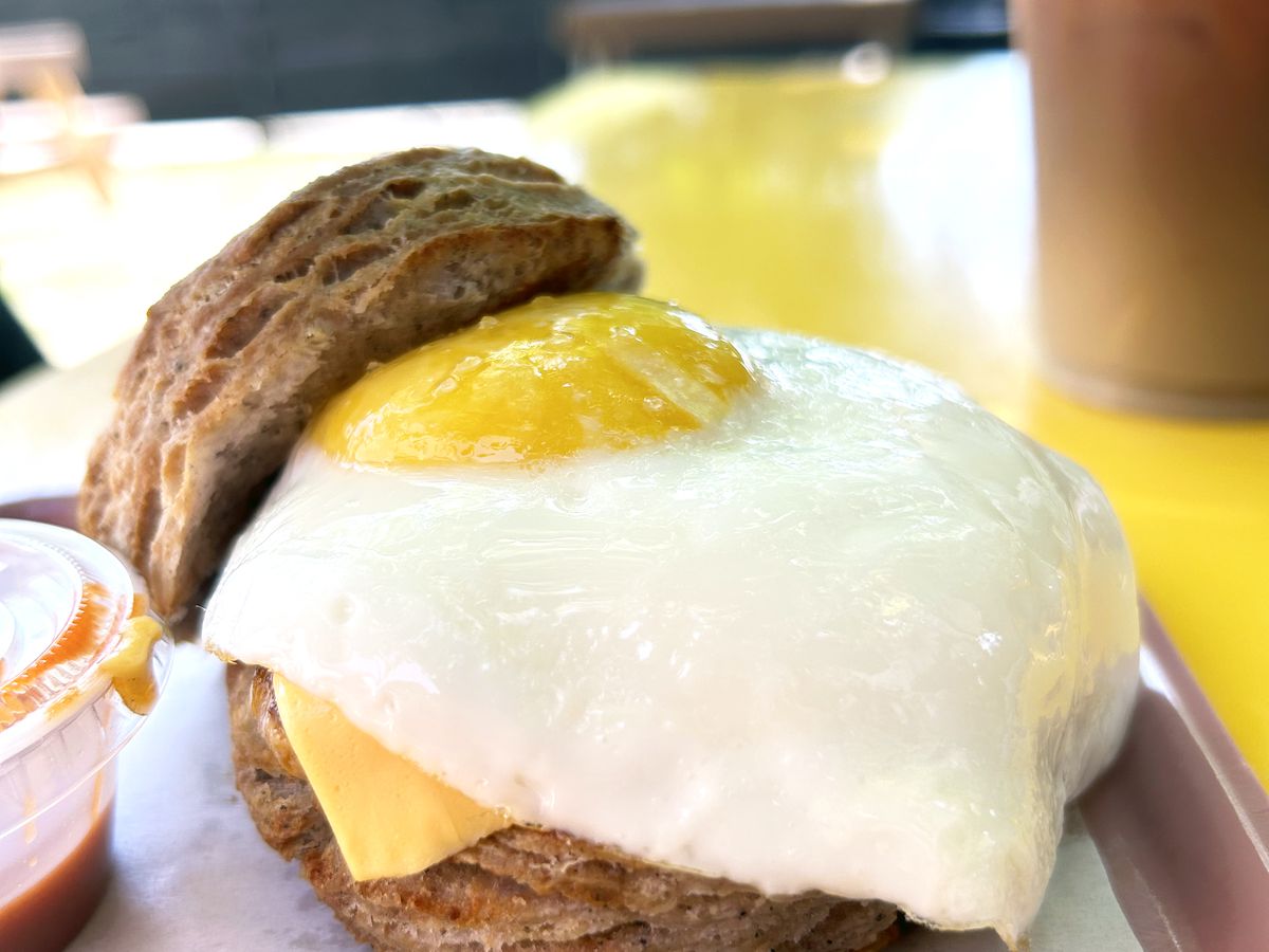 A biscuit sandwich with an egg on it.