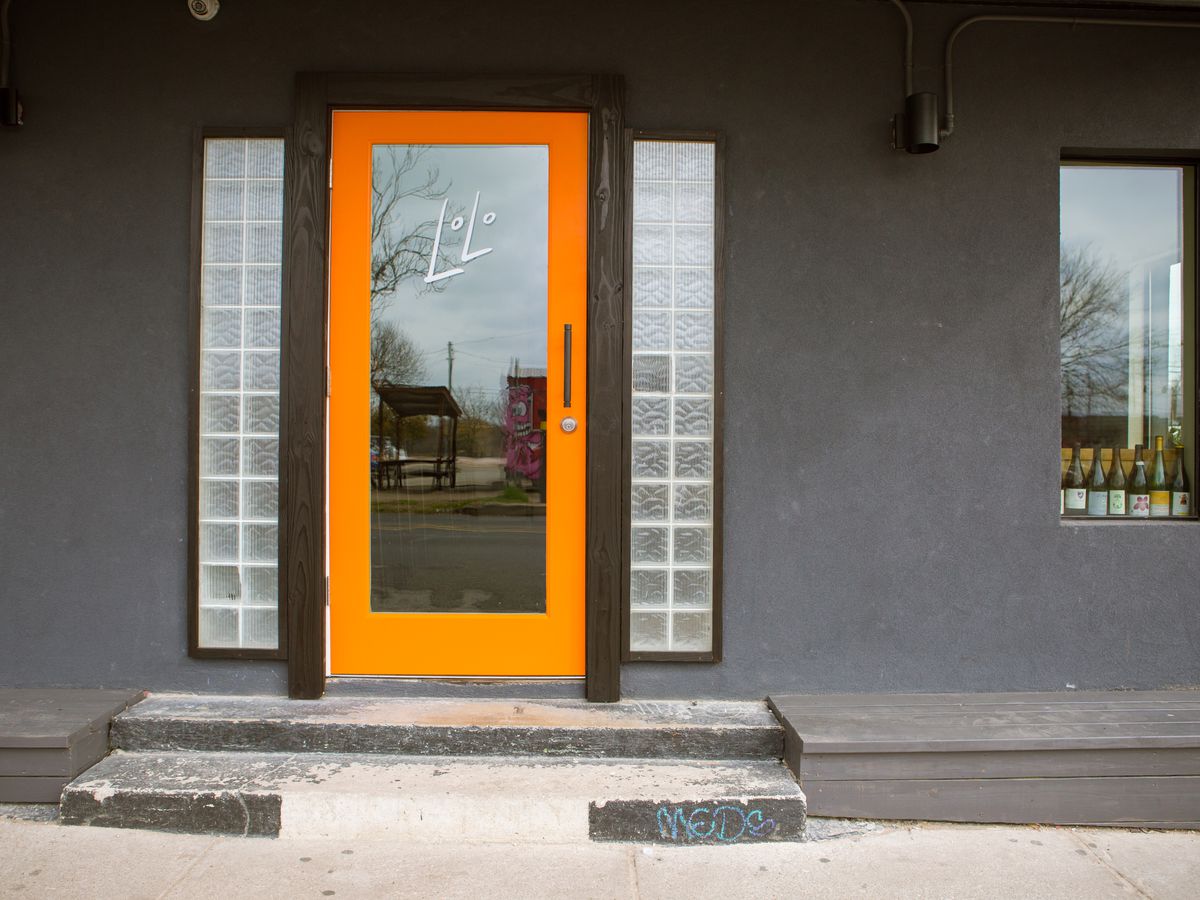 Lolo wine bar’s exterior with an orange trim door
