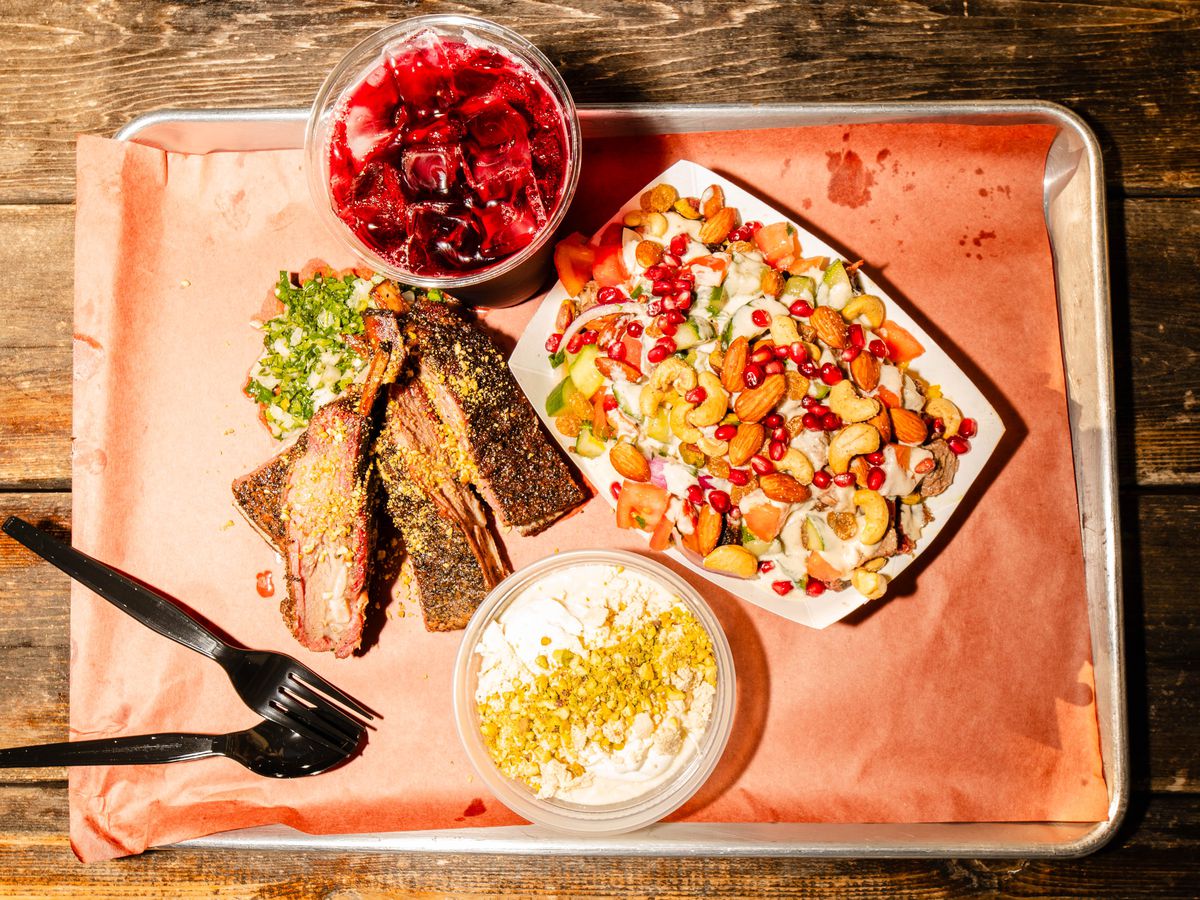 A tray of ribs, a cardboard tray of rice and nuts and a dessert in a container.