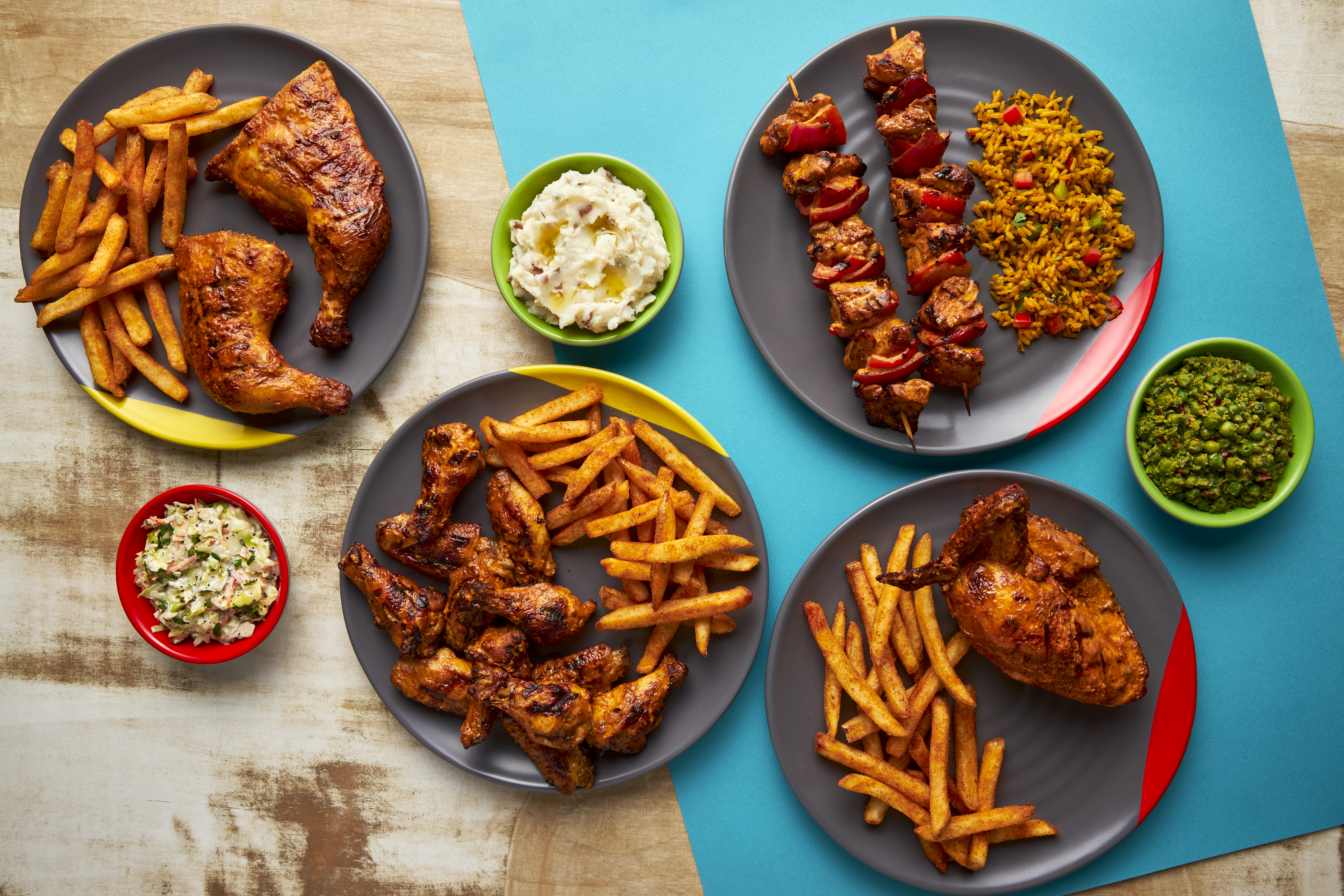 A table of chicken and other foods in plates.
