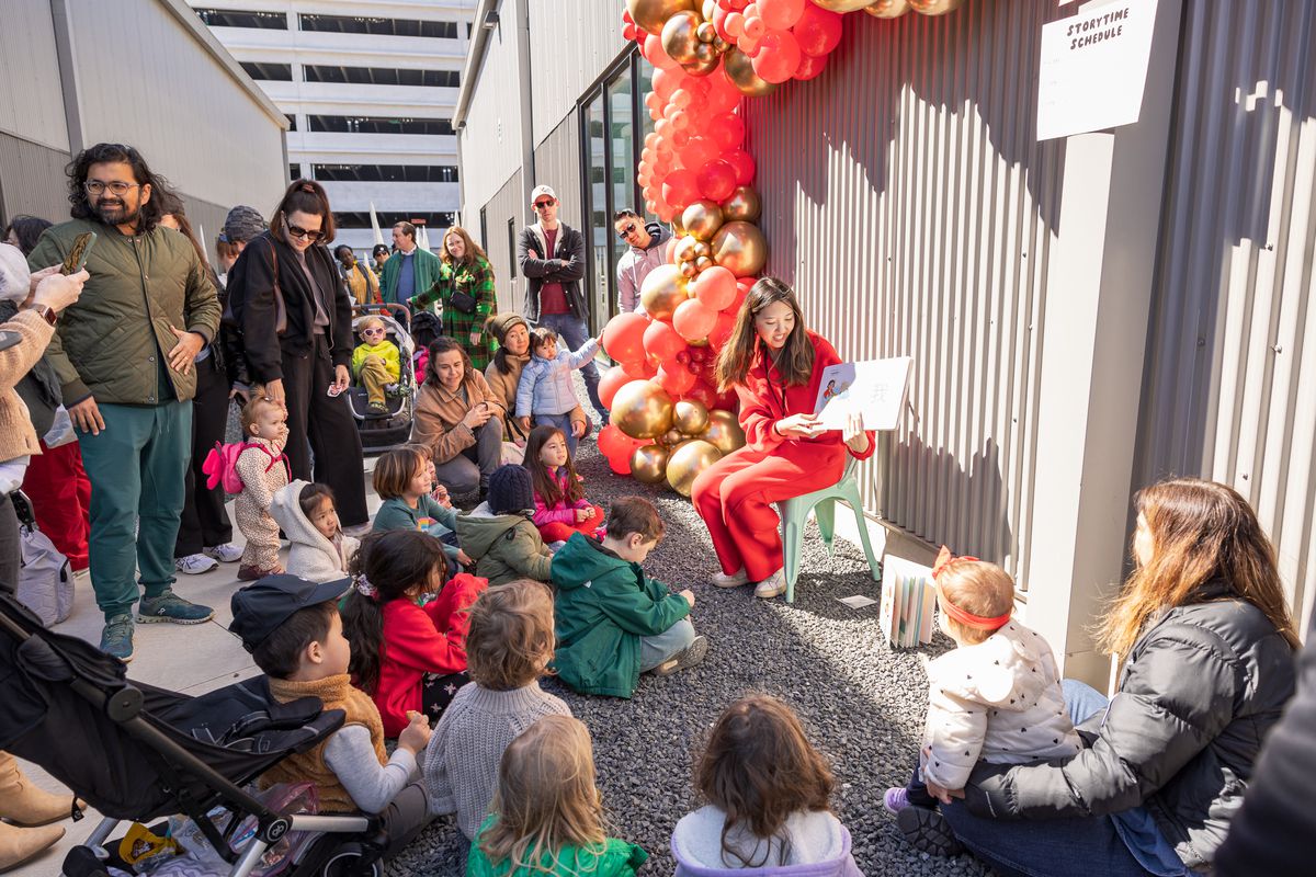 An author reads to a group of adults and children at the Lunar New Year Festival in East Austin.