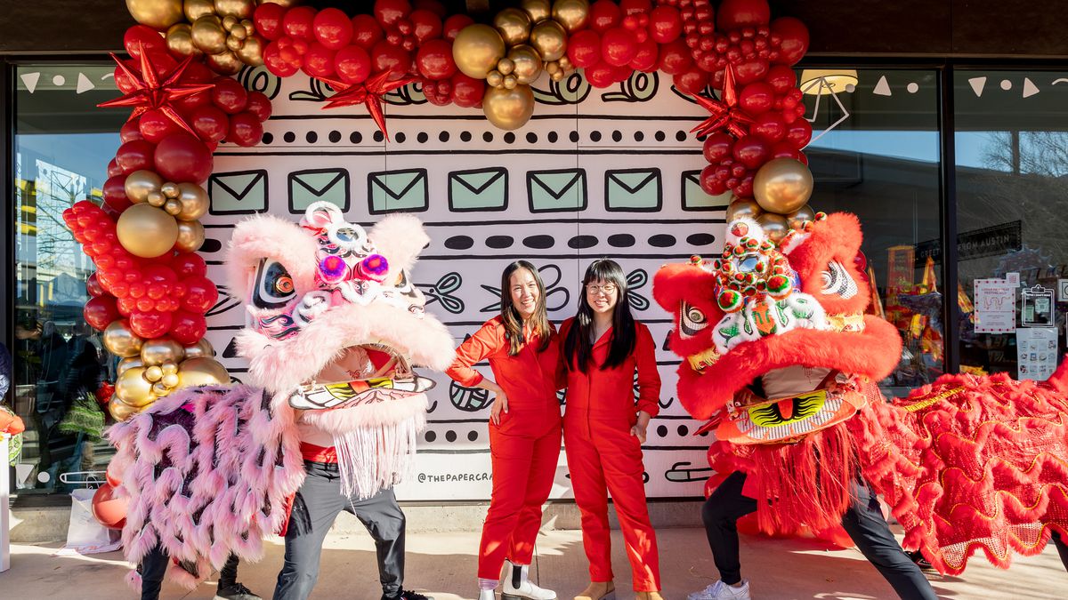 Kathy Phan and Pei Sim pose for a picture next to dragon dancers.