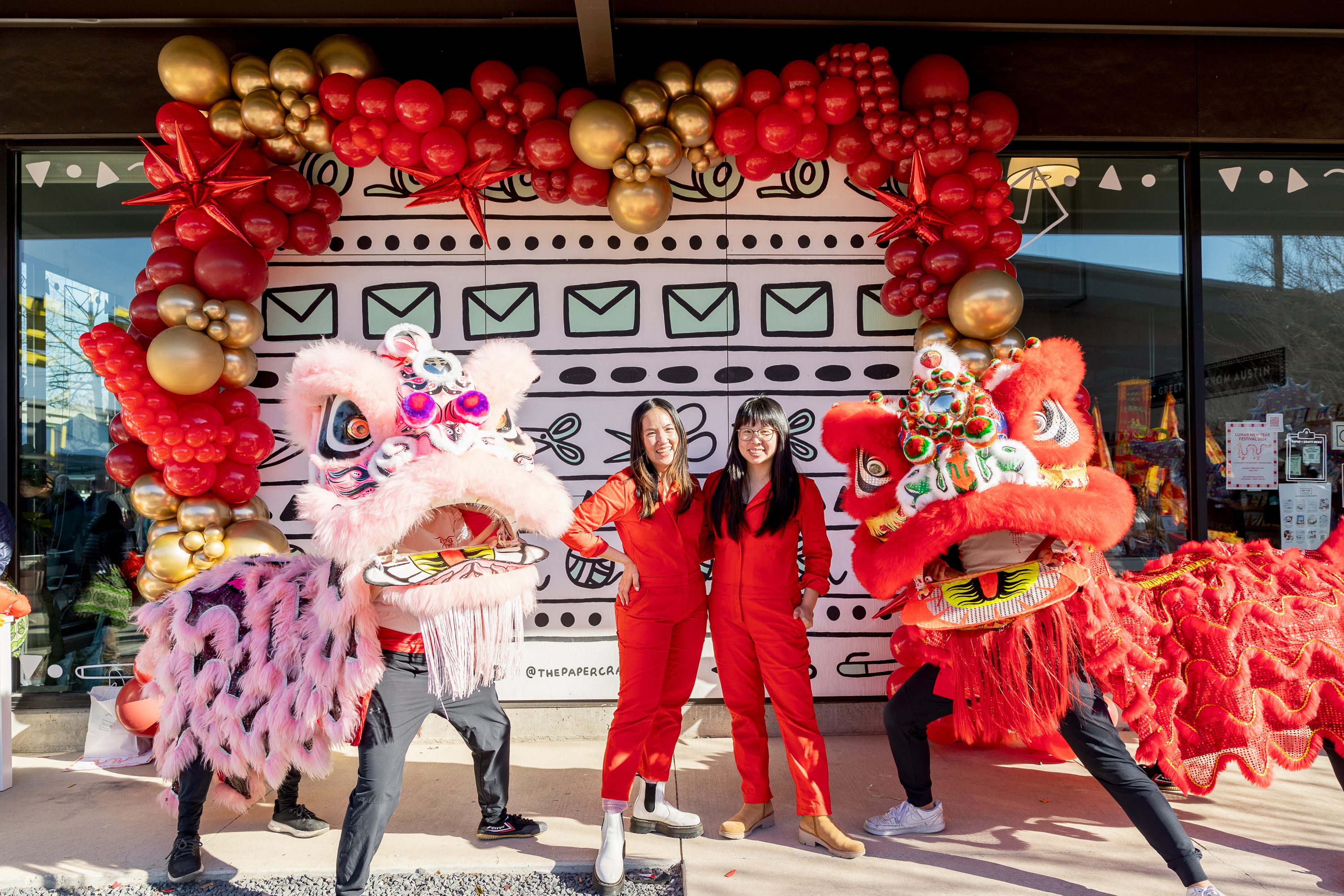 Kathy Phan and Pei Sim pose for a picture next to dragon dancers.