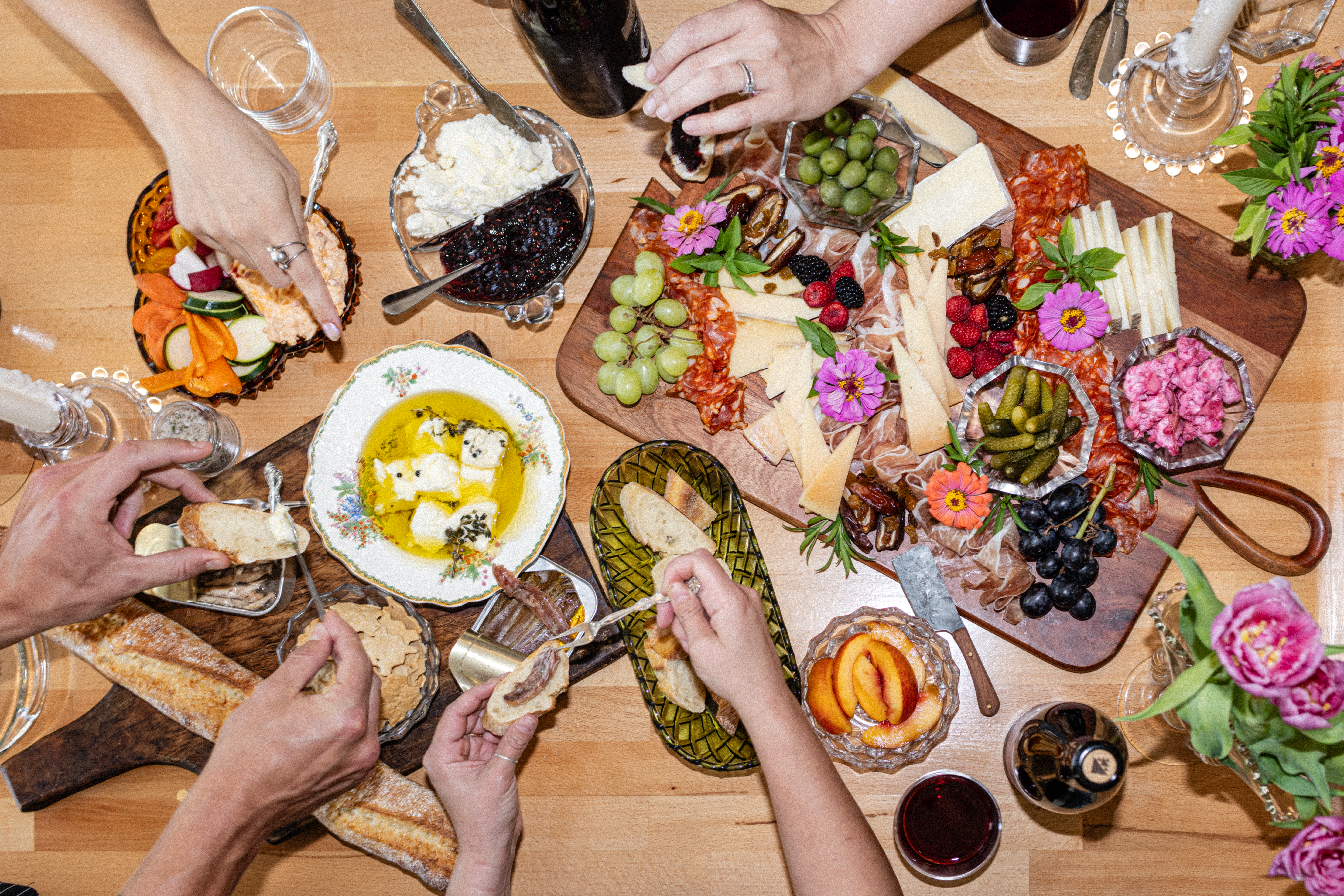 A table full of foods and dips and cheese and meats.