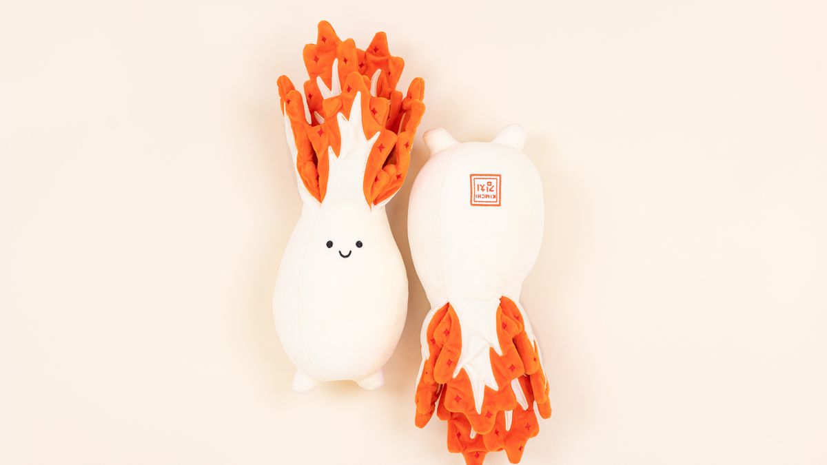 Two kimchi plushies lay side by side.