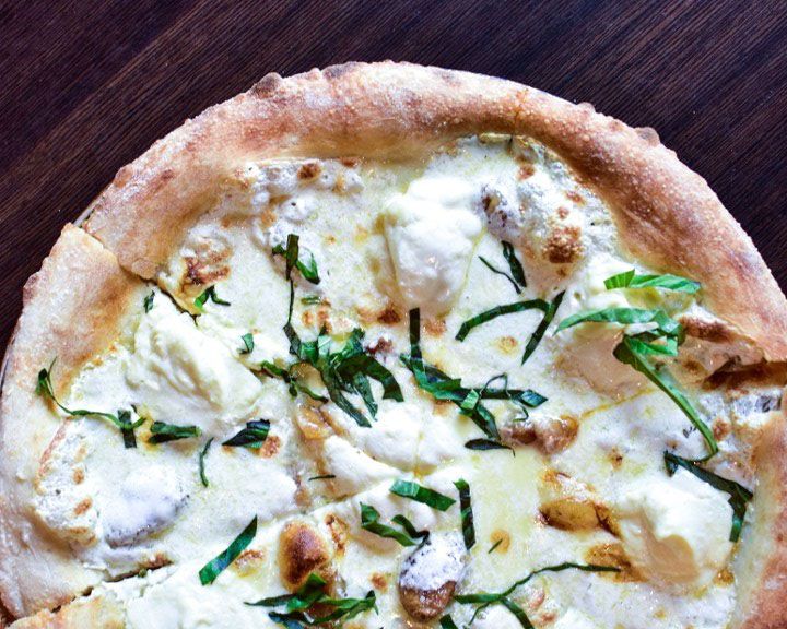Half a white pizza is shown, sitting on a table.