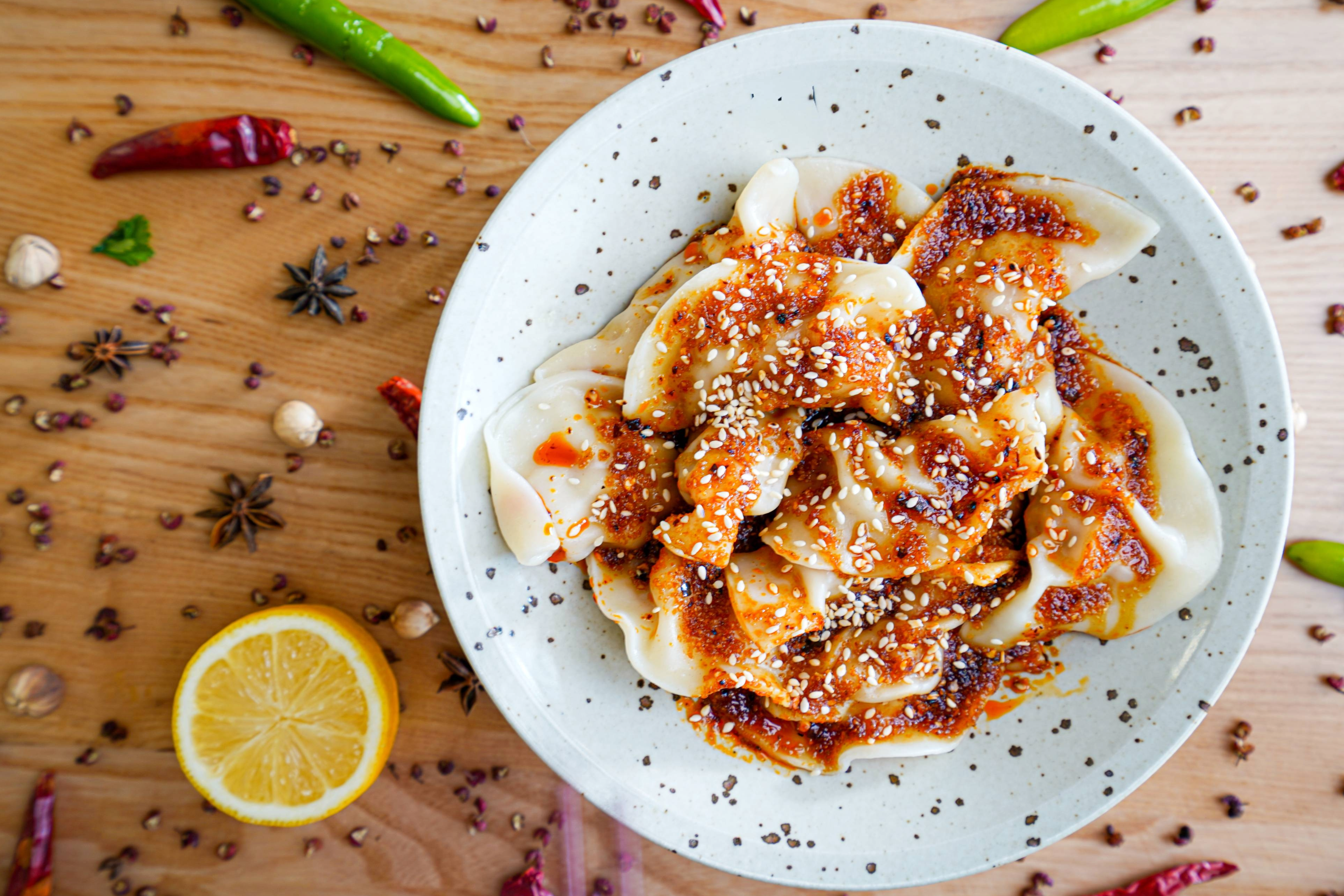 A plate of dumplings doused in a red oil.